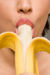 Young woman eating banana